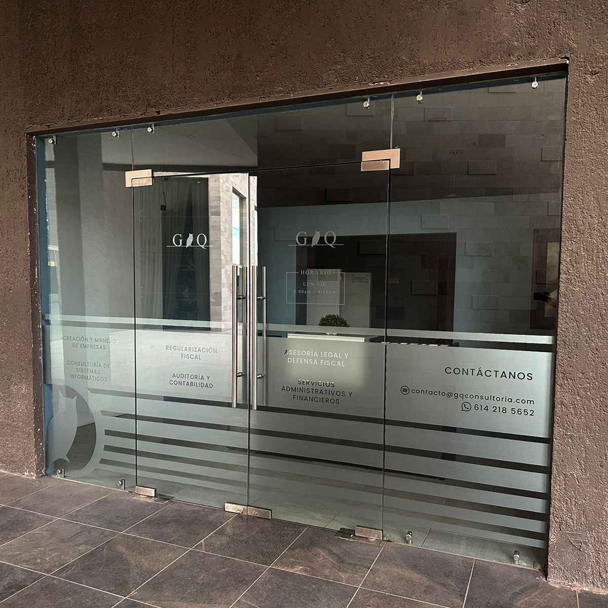 Fachada acristalada con vinil de corte efecto vidrio arenado: logotipo, servicios y señalética de empresa