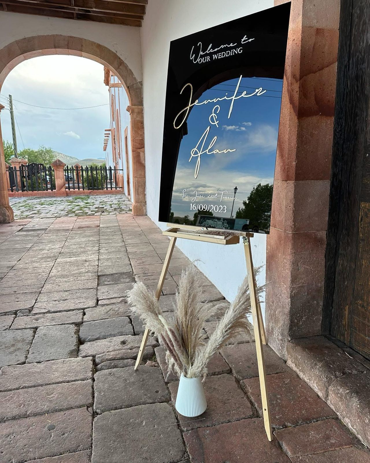 Letrero de bienvenida para boda en acrílico negro con nombres en relieve dorado cortado a láser