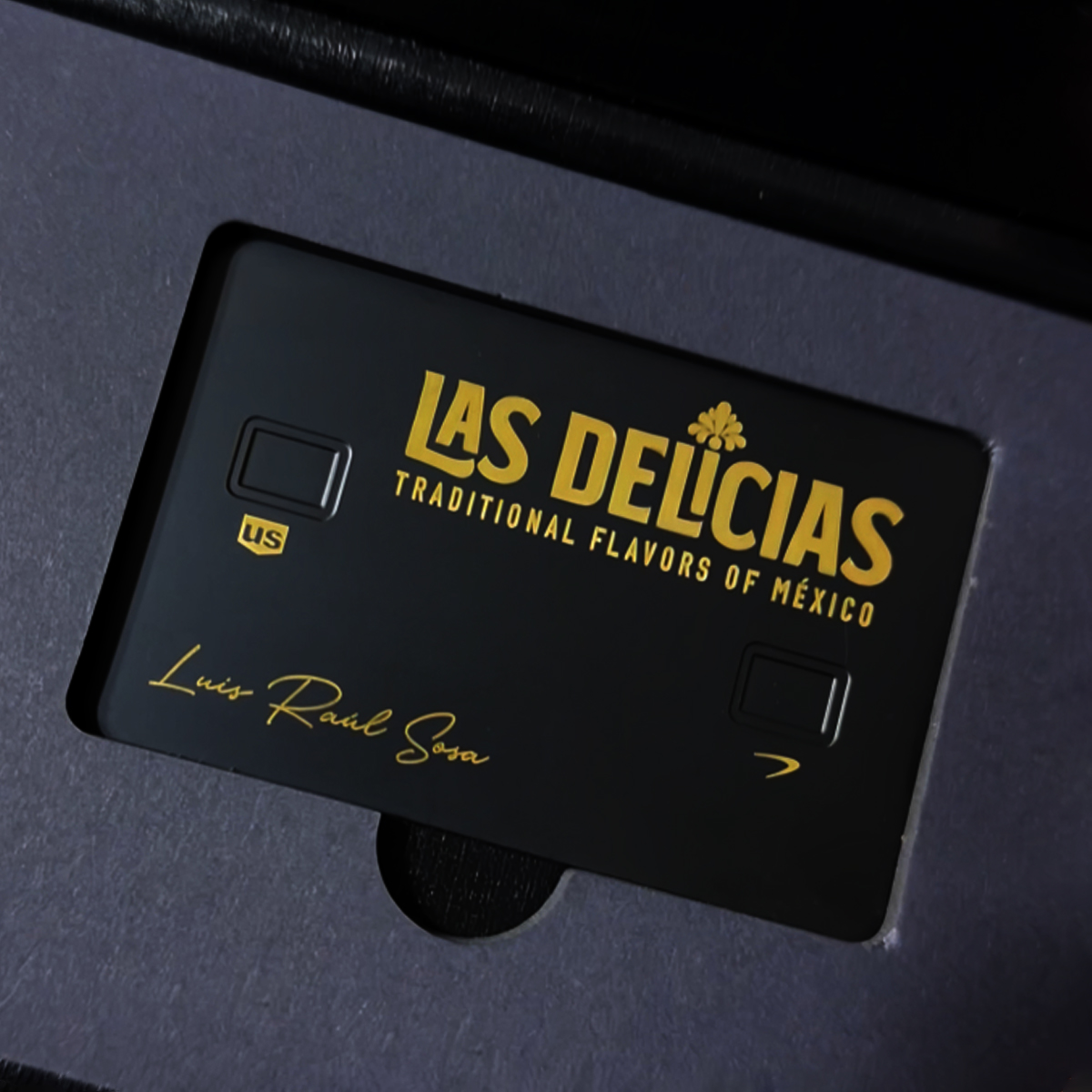 Tarjeta premium negra con grabado láser dorado marca Las Delicias y texto personalizado